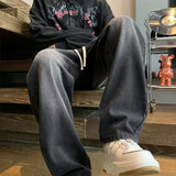 Japanese-style Drawstring Elastic-waist Jeans For Men styled with a black hoodie and white sneakers.